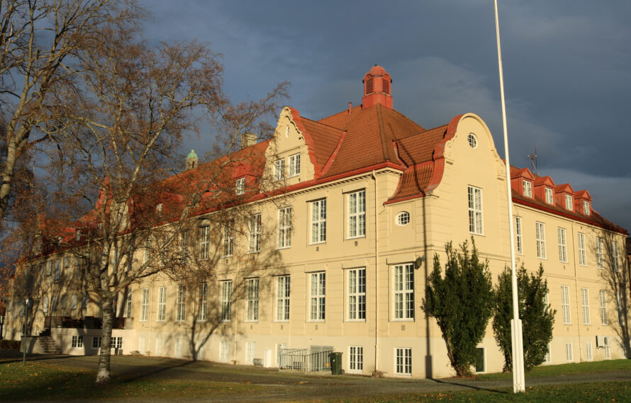Bilde av hovedbygget i solnedgang fra kortsiden